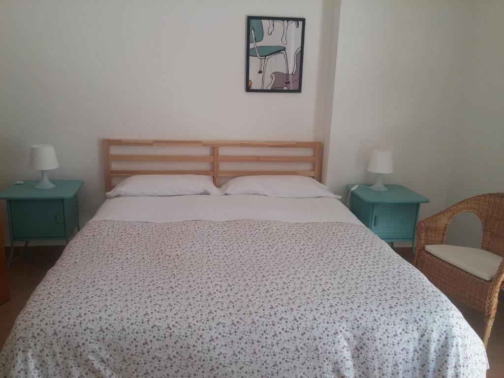 a bedroom with a bed with two tables and two lamps at Akron B&B in SantʼAlessio Siculo