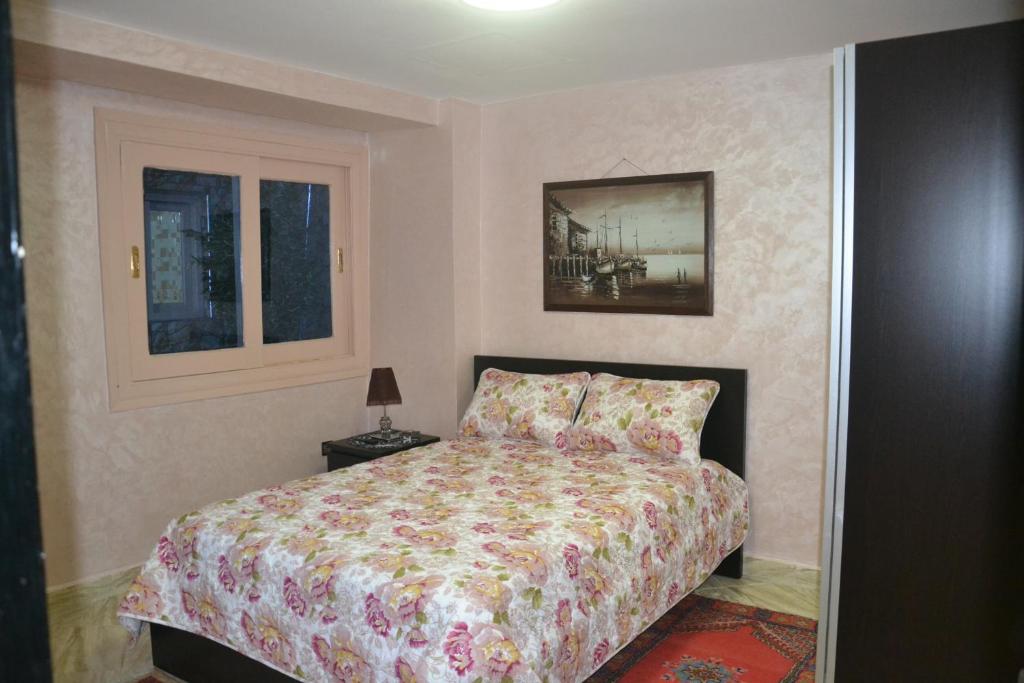 Un dormitorio con una cama y un cuadro en la pared. en House City Center, en Rabat