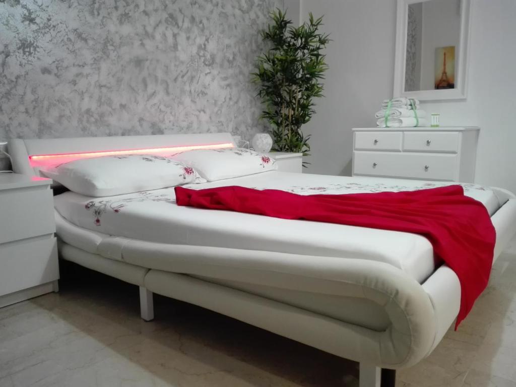 una camera con un letto bianco e una coperta rossa di Mecenate Cozy Flat a Milano
