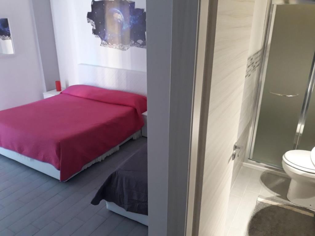 a bedroom with a pink bed and a toilet at Casa Normanna in Monreale