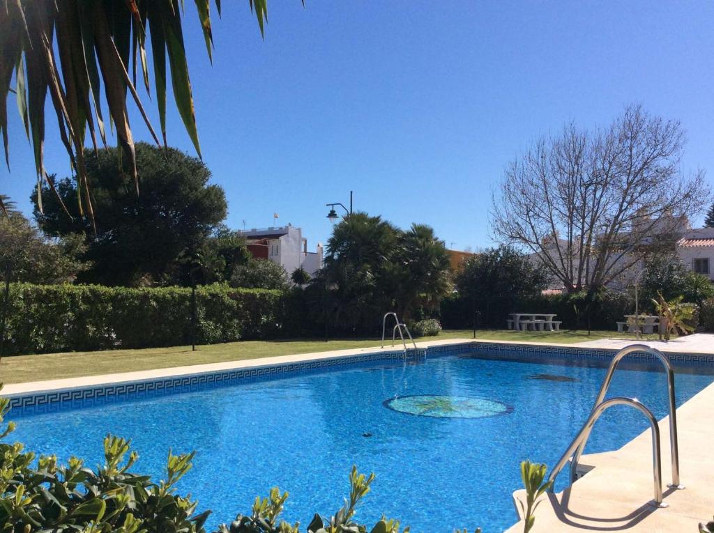 a large blue swimming pool in a yard at Del Parque Flats - Guadalmar - Beach & Relax in Málaga