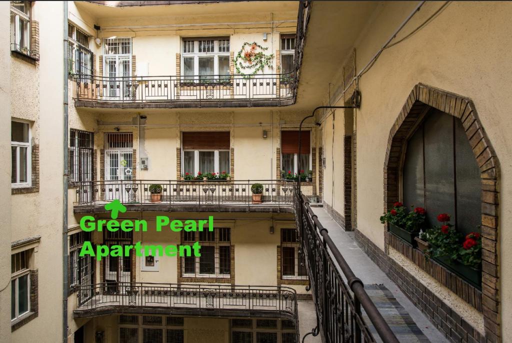 ブダペストにあるGreen Pearl Apartment at St Stephen' s Basilicaの緑真珠のアパートメントを読む看板のあるアパートメントビル
