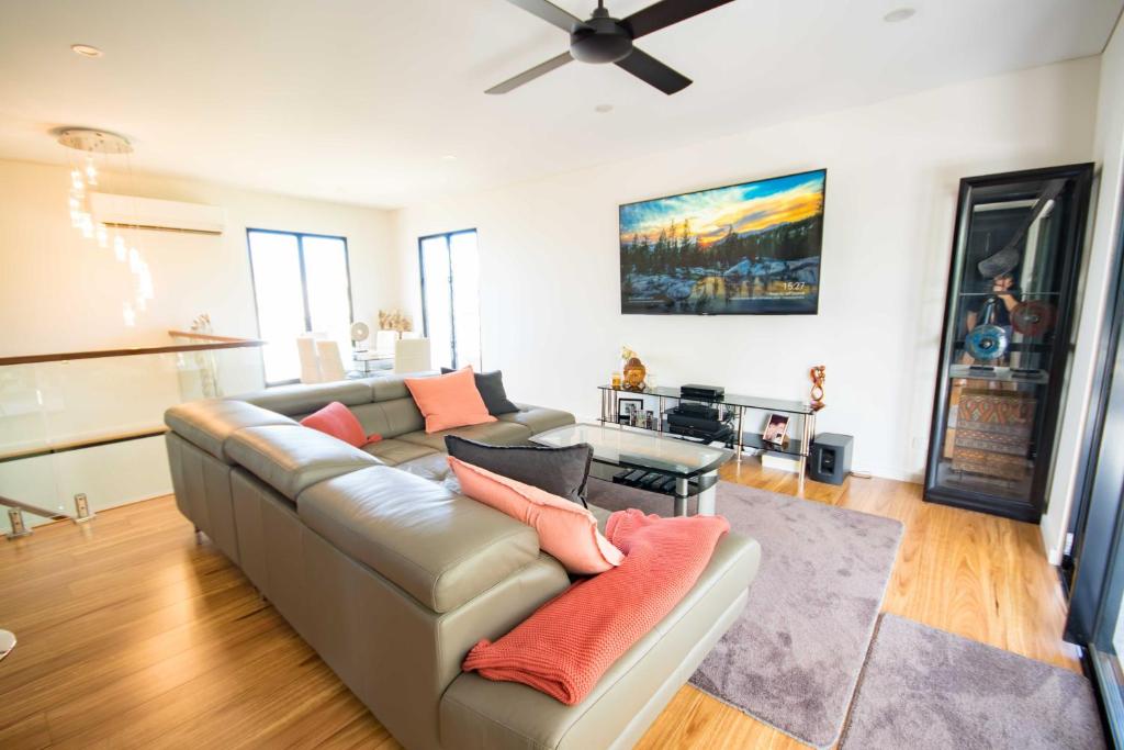 un soggiorno con divano e ventilatore a soffitto di Beautiful Modern Luxury a Townsville