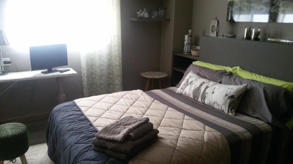 um quarto com uma cama, uma secretária e um computador em la casa gris em Alicante