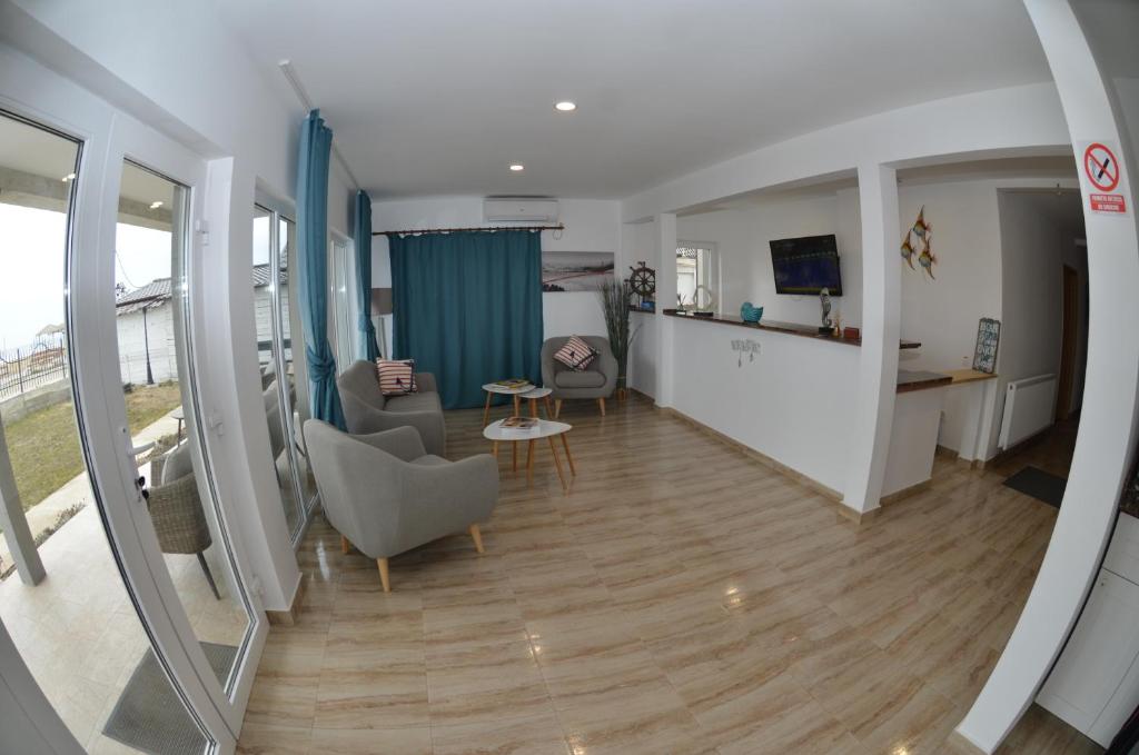 a living room with a couch and chairs and a table at California Dreaming in Mamaia Sat/Năvodari