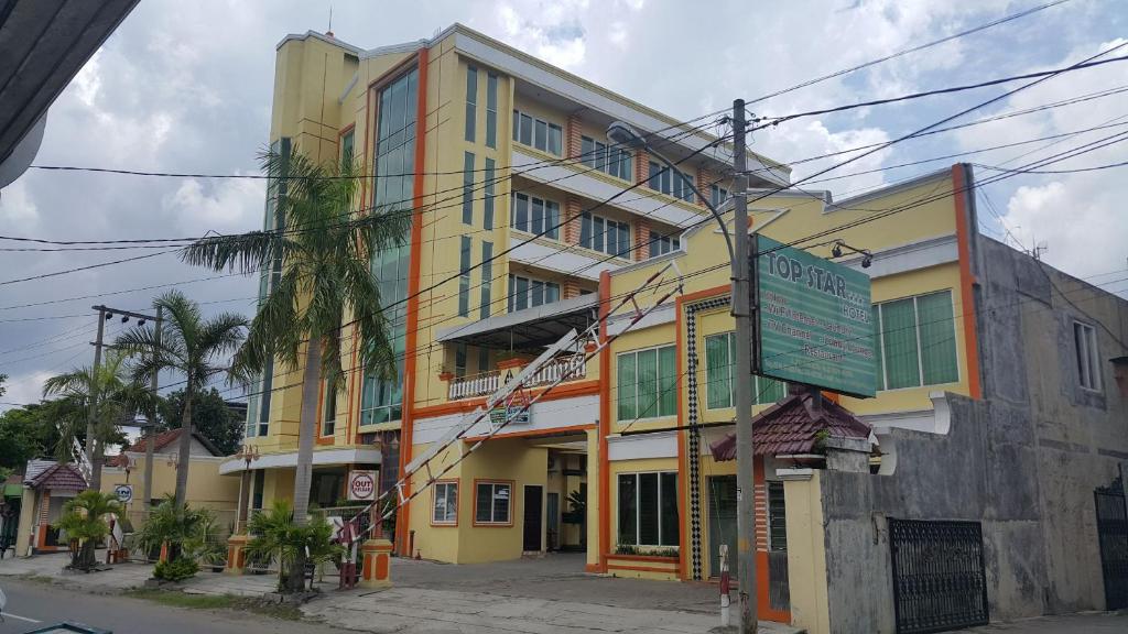 un edificio amarillo con un cartel delante en Top Star Hotel, en Cepu