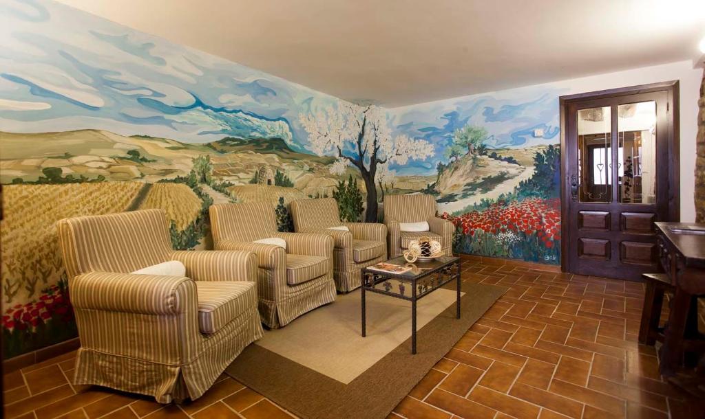 エルシエゴにあるCasa Rural La Corcheaの壁画のあるリビングルーム