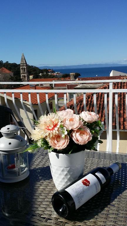 a bottle of wine and a vase with flowers on a balcony at Dreams in Makarska