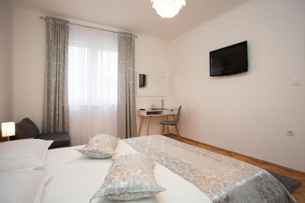 um quarto com uma cama e uma televisão na parede em Split Center Beautiful Apartment em Split