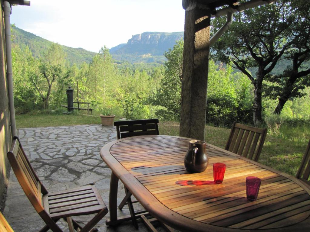 einen Holztisch mit zwei Tassen auf einer Terrasse in der Unterkunft L'Oursiere in Bédouès