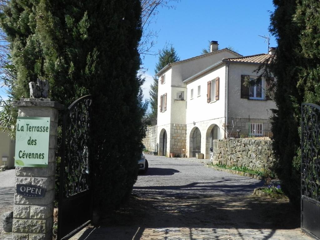 een poort naar een huis met een bord erop bij La Terrasse des Cevennes in Ribes