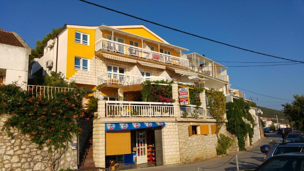 a yellow and white building on a city street at Apartmani Jelena in Neum