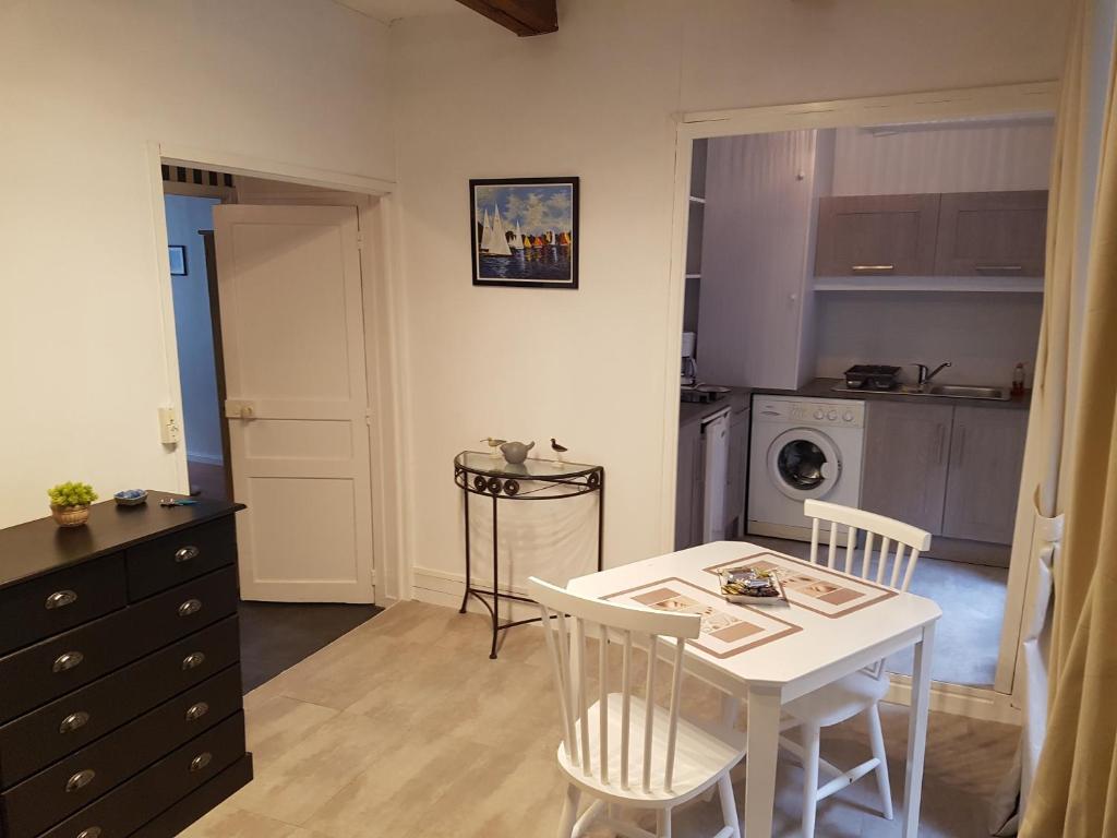 a kitchen with a white table and chairs and a table and a kitchen at Granville hyper centre in Granville