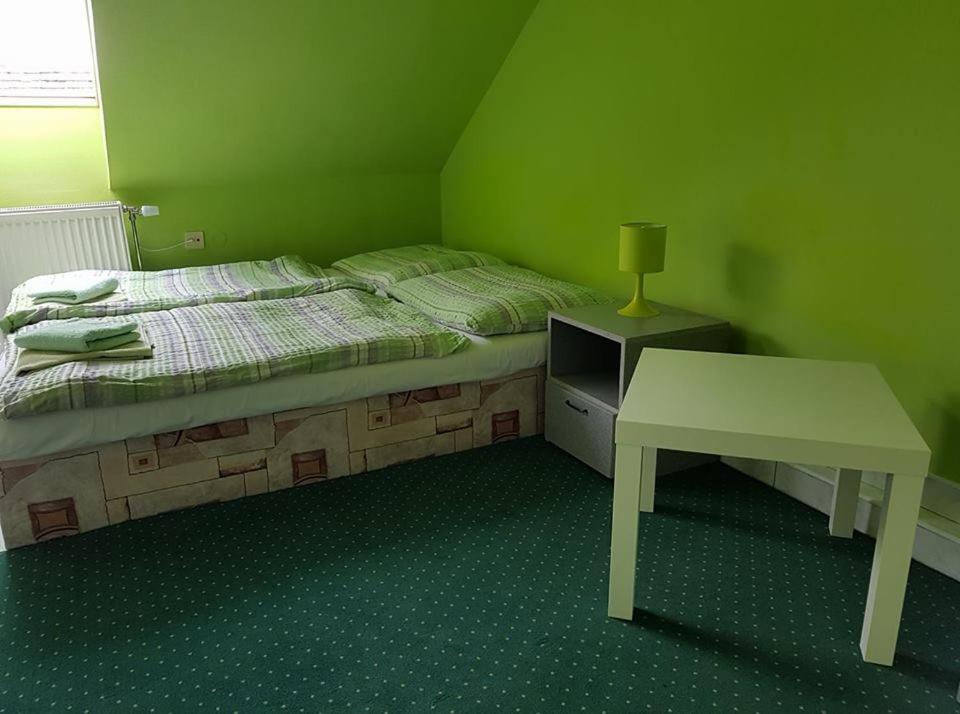 A bed or beds in a room at Penzión KORMOŠ