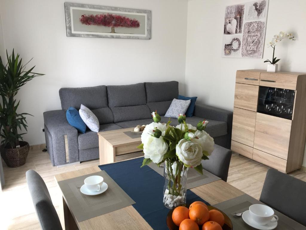 una sala de estar con una mesa con un jarrón de flores en Apartment near Yumbo and Cita, en Playa del Inglés