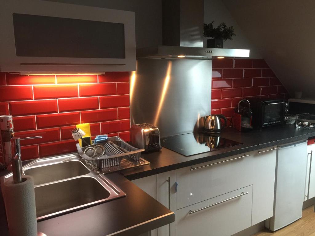 een keuken met een wastafel en een rode bakstenen muur bij appartement romantique tout confort 4 personnes in Boulogne-sur-Mer