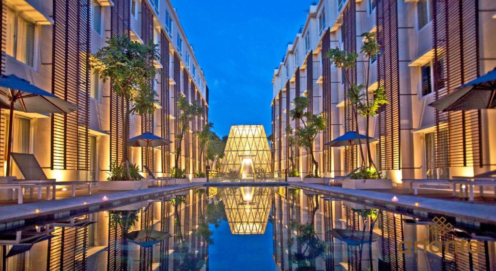 un reflejo de un canal entre dos edificios en Ananta Legian Hotel en Legian