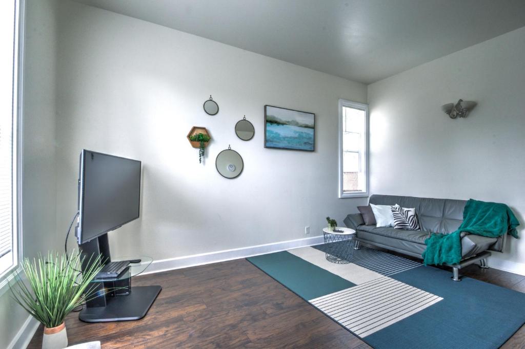 ein Wohnzimmer mit einem Sofa und einem TV in der Unterkunft Cozy 2 bdr Apt at heart of Capitol Hill - Apt A in Seattle