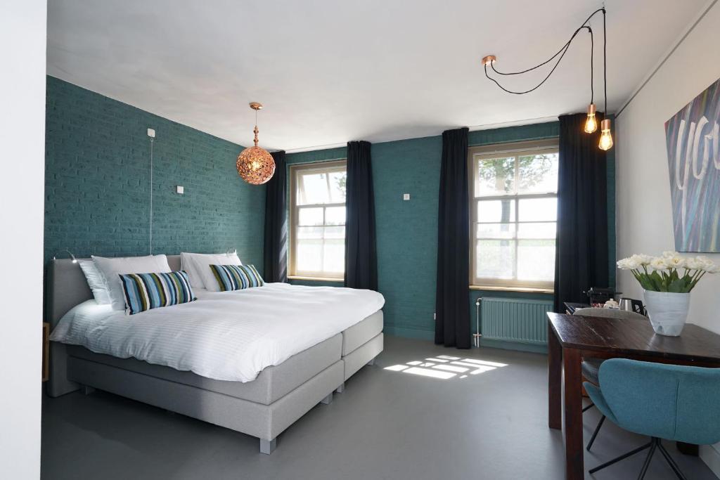 a bedroom with a bed and a green wall at De Kempse Hoeve B&B in Boxtel