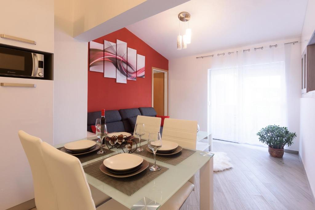 comedor y sala de estar con mesa y sillas en Apartmani Judita en Zadar