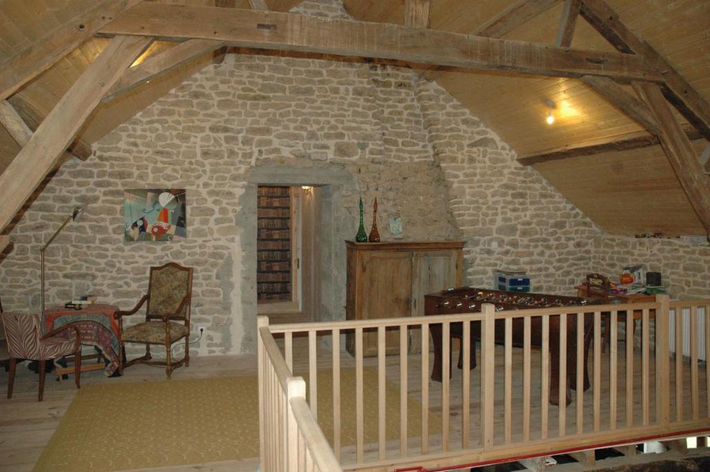 Zimmer mit einer Steinmauer mit einem Tisch und Stühlen in der Unterkunft Hello velo in Tintury