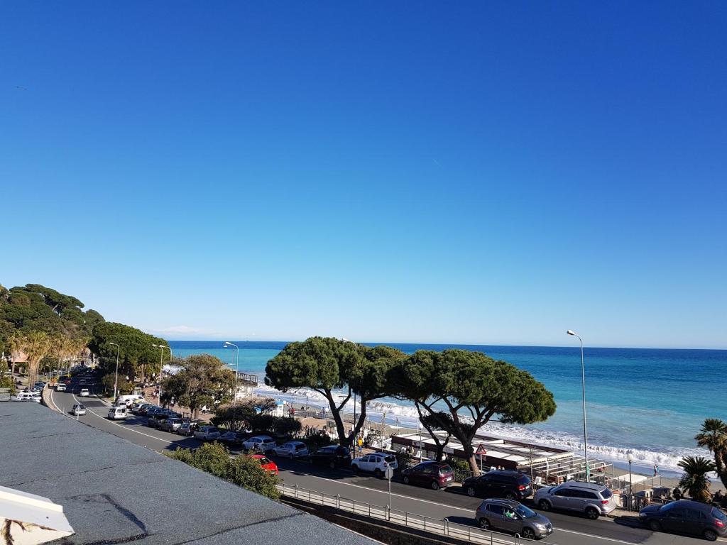 vistas a una playa con coches aparcados en la carretera en Hotel Villa Costa, en Celle Ligure