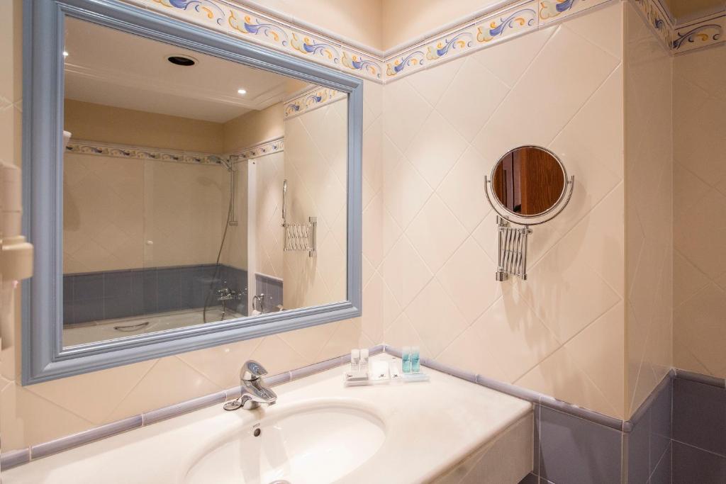 a bathroom with a sink and a mirror at Hipotels Barrosa Garden in Chiclana de la Frontera