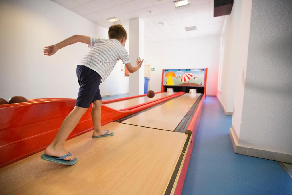 a young boy playing a game of bowling at Hipotels Barrosa Garden in Chiclana de la Frontera
