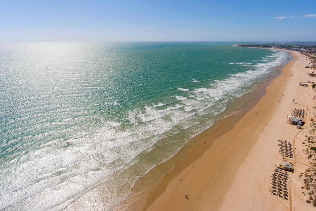 an aerial view of the beach and ocean at Hipotels Barrosa Garden in Chiclana de la Frontera