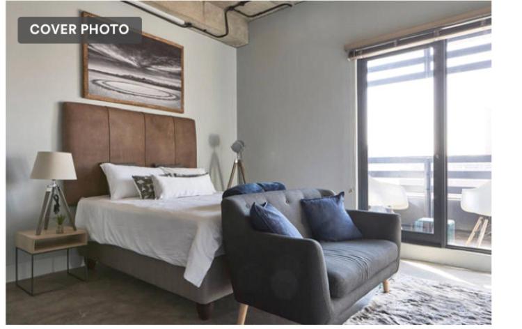 um quarto com uma cama, um sofá e uma janela em Urban sky studio @ Hallmark House em Joanesburgo