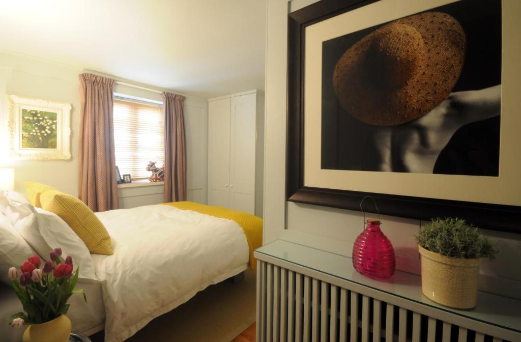 a bedroom with a bed and a picture on the wall at Mulberry cottage in Cheltenham