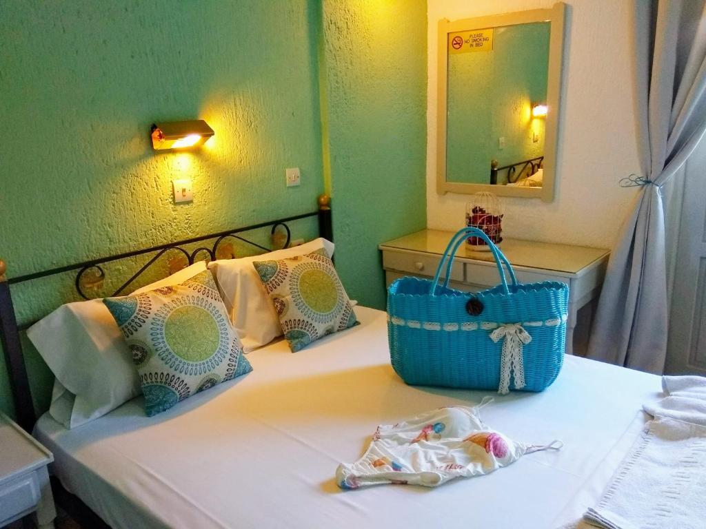 a room with a bed with a purse and a mirror at Orion Apartments in Malia