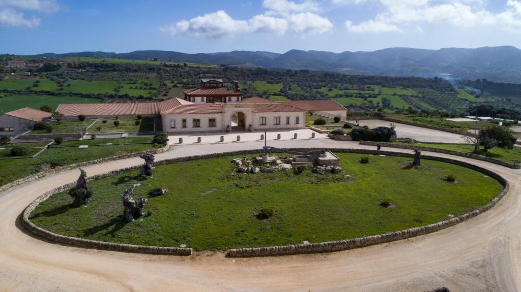 an aerial view of a large building with a green field at Locanda Gulfi in Chiaramonte Gulfi