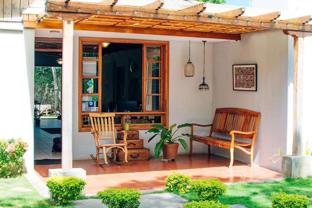 un patio con 2 sillas y una pérgola en La Bicicleta Hostal, en Managua