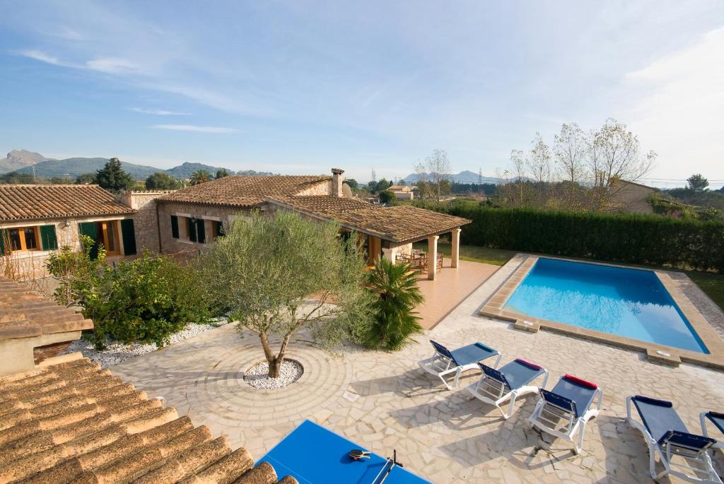 an external view of a house with a swimming pool and chairs at Villa Truc in Pollença