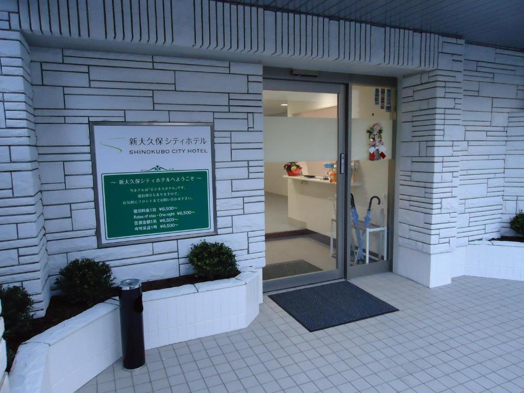 un bâtiment avec un panneau à l'avant dans l'établissement Shin-Okubo City Hotel, à Tokyo