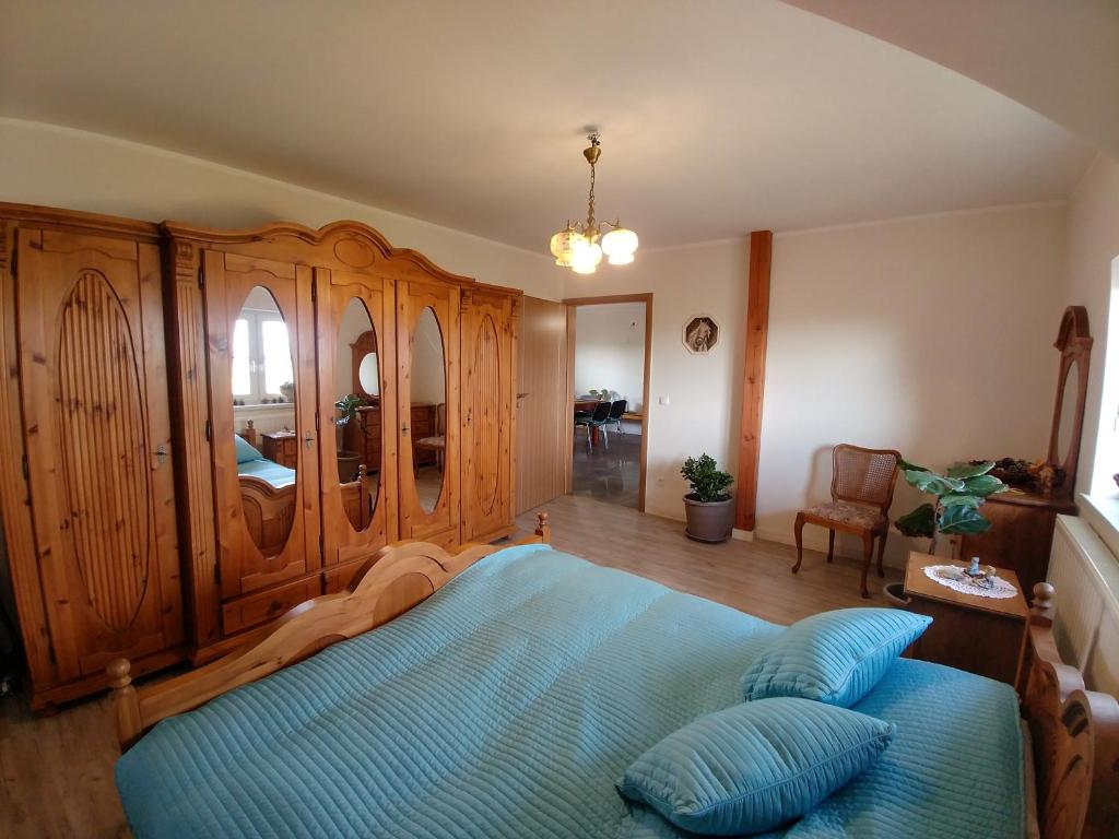 1 dormitorio con 1 cama azul y armario de madera en Lawendowa Galeria, en Krapkowice