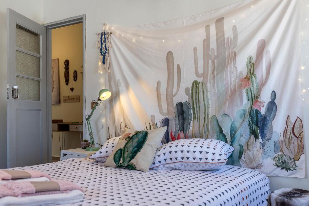 a bedroom with a bed with a mural of cactus at Cramé House in Cortegaça