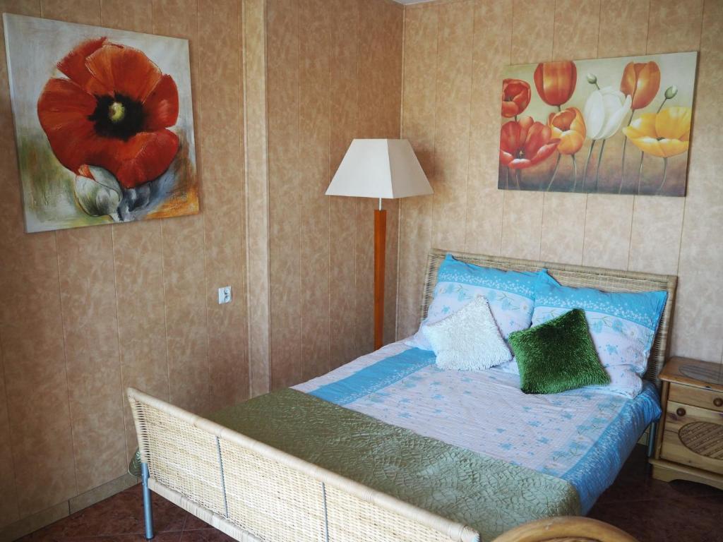Cama pequeña en habitación con pinturas en la pared en Dom Gościnny Anastazja en Międzywodzie