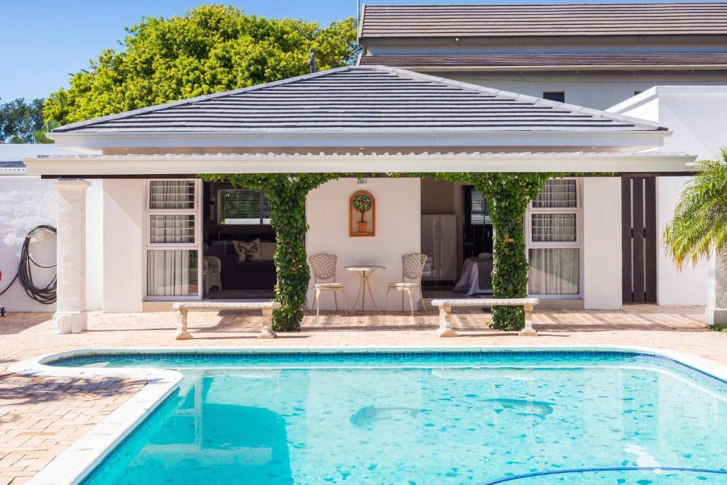 una piscina frente a una casa en The Studio en Port Elizabeth