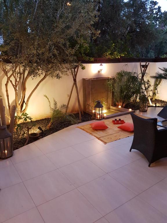 馬拉喀什的住宿－Duplex prestige hivernage，庭院配有桌椅和树木