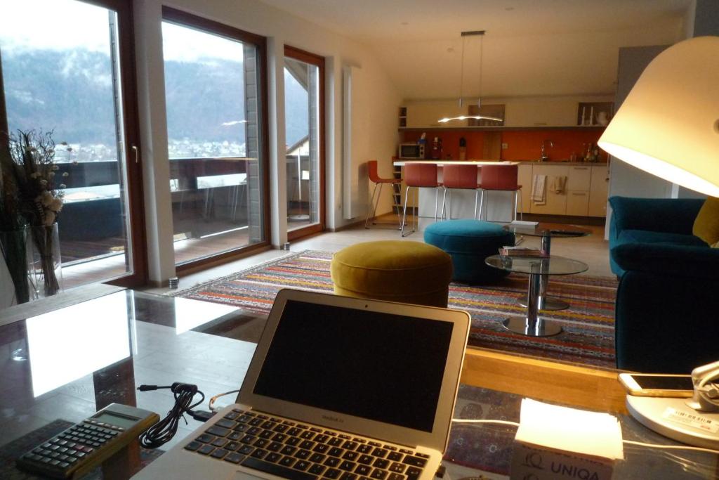a laptop computer sitting on a glass table in a living room at Villa Bellevue Apartment 1 Deluxe Apartment in Ossiach