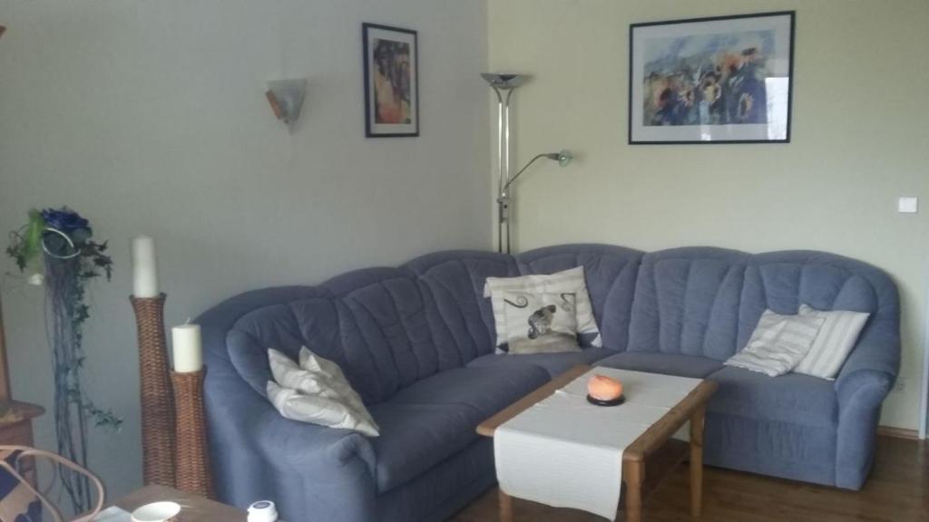 a blue couch in a living room with a table at Ferienwohnung Ackermann Oberallgäu in Missen-Wilhams