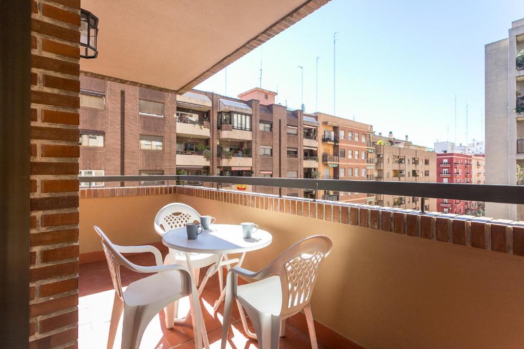 a table and chairs on a balcony with a view at ApartUP Mestalla Home in Valencia