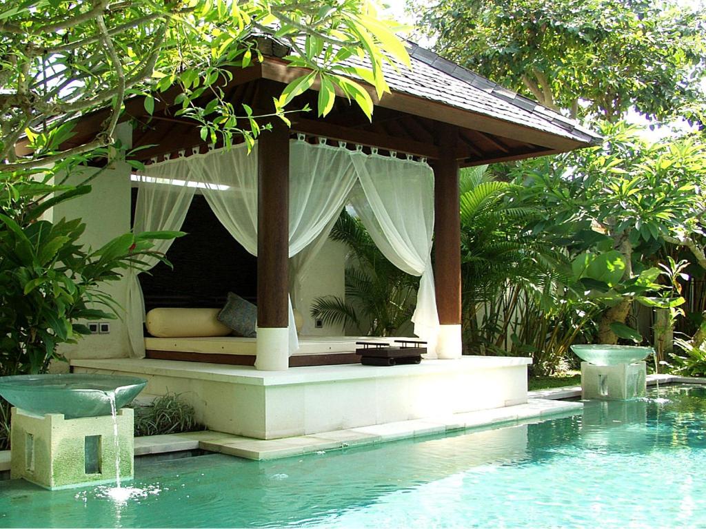 
a large swimming pool with a canopy on top of it at Nike Villas in Sanur
