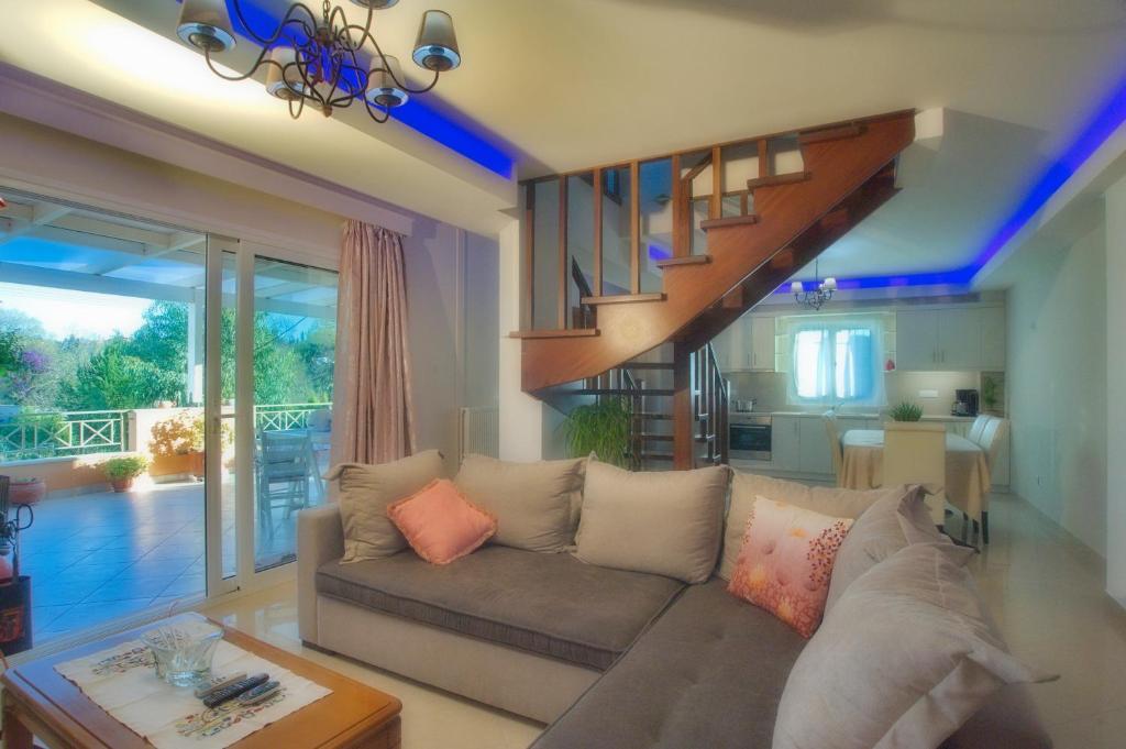 a living room with a couch and a staircase at Corfu Villa Potamaki in Corfu