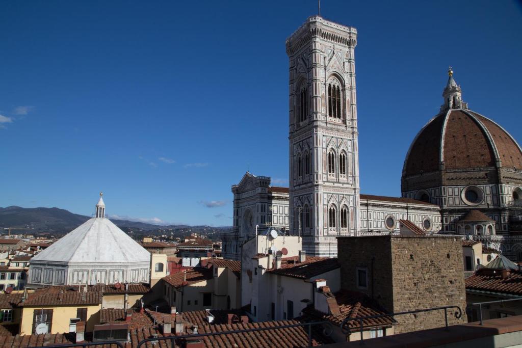 un grand bâtiment avec une tour d'horloge dans une ville dans l'établissement Hotel Medici, à Florence