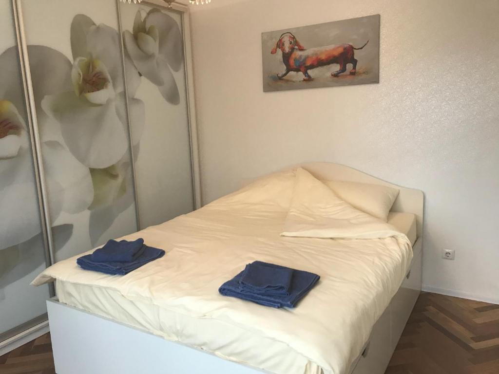 Una habitación con una cama con dos toallas azules. en Sunny apartment overlooking the royal village, en Kiev