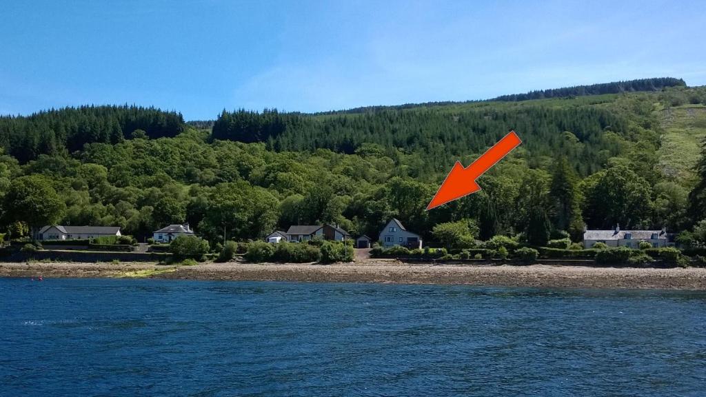 a red object is flying over a body of water at Trefoil Holiday Home in Strachur