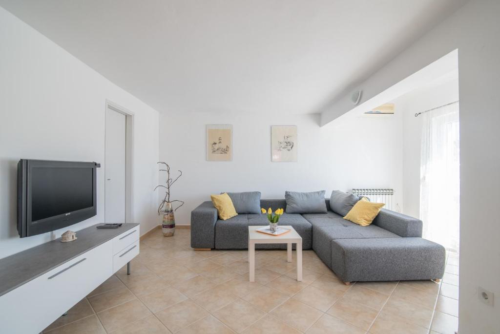 a living room with a couch and a tv at Apartment Lavanda in Premantura